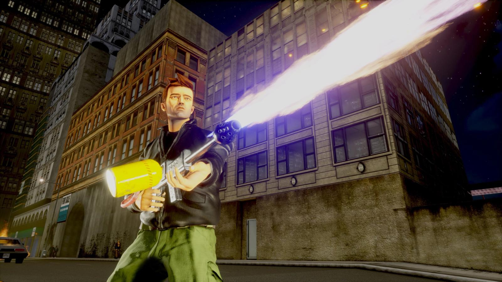 A man in green cargo pants and a leather jacket stands in front of some industrial-looking buildings, firing a flamethrower.