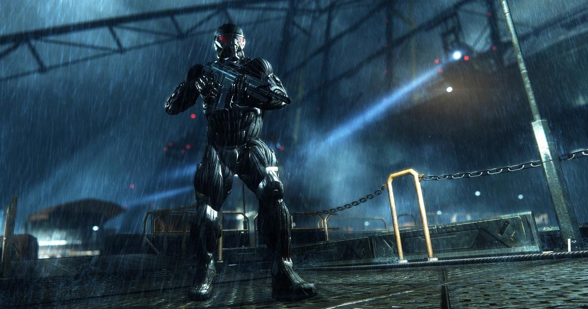 Crysis Trilogy Remastered, man in black armour holding a gun, standing on docks at night in the rain