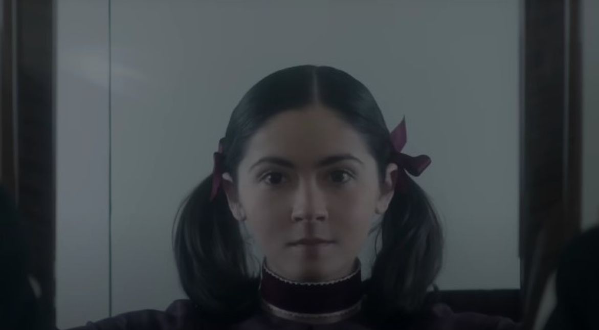 Orphan: First Kill Isabelle Fuhrman as Esther/Leena Klammer looking straight into camera while opening closet doors