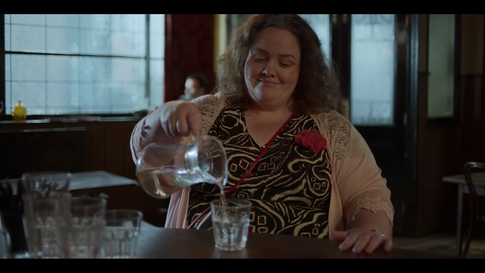 Jessica gunning as Martha on Baby Reindeer pouring water in a glass
