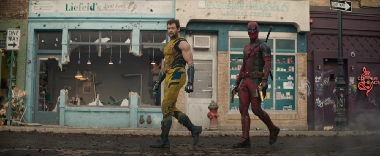 deadpool and wolverine walking past a bar