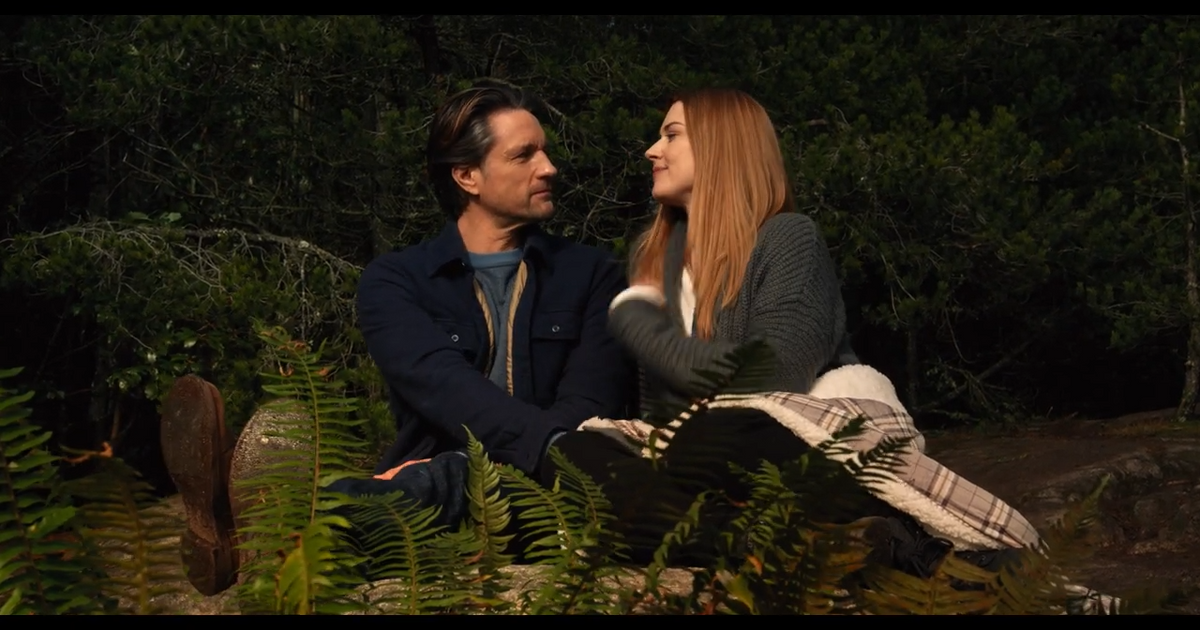 Virgin River Martin Henderson as Jack Sheridan and Alexandra Breckenridge as Melinda Monroe sitting in the woods