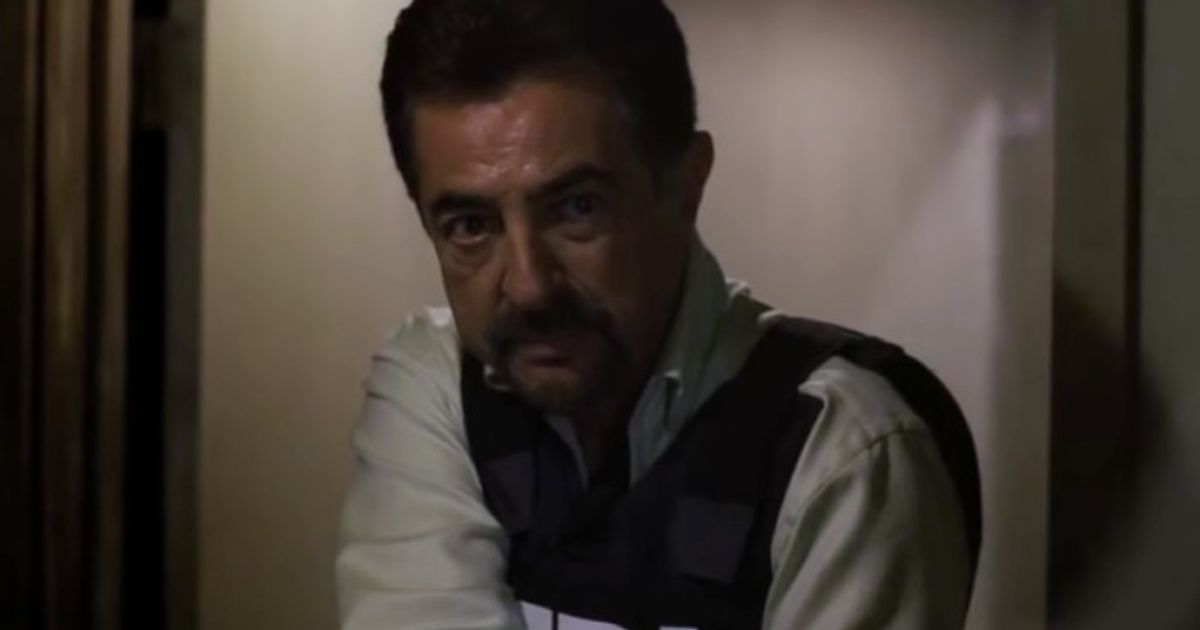 Criminal Minds Joe Mantegna as David Rossi holding a gun and wearing FBI vest