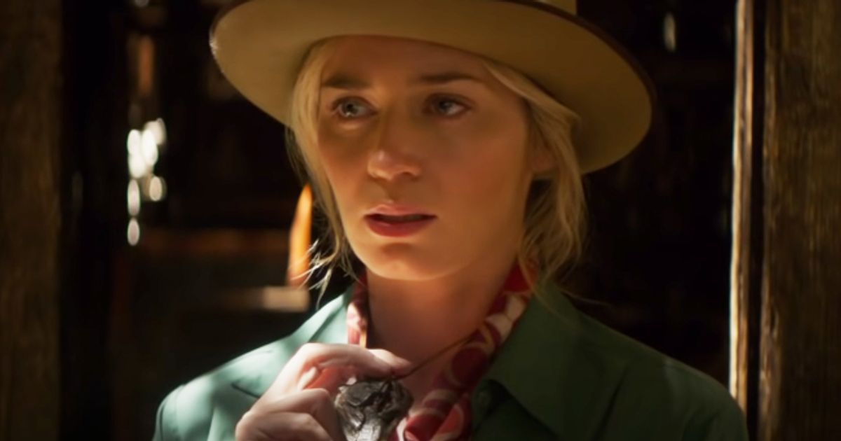 Emily Blunt wearing hat and holding necklace